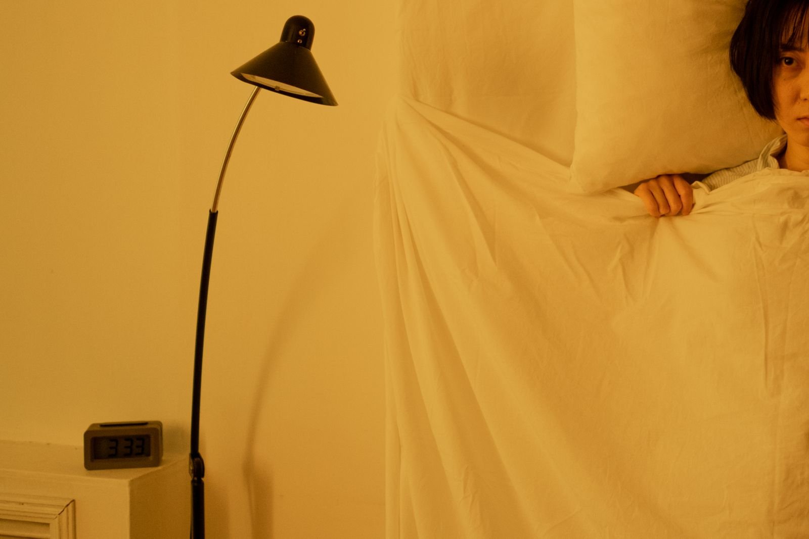 Mulher acordada segurando o lençol às 3 da manhã, sem conseguir dormir de ansiedade